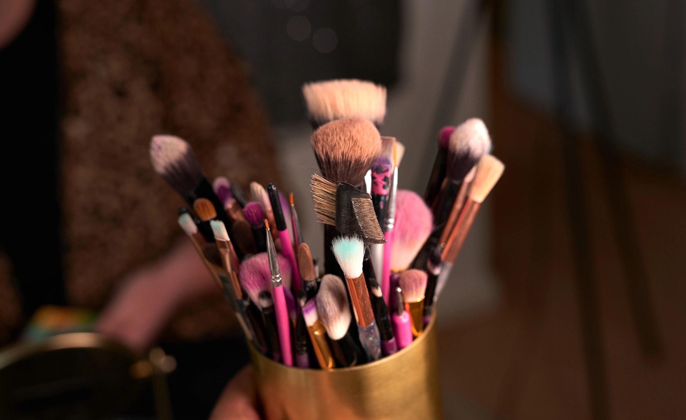 Makeup brushes in a container on a backstage table