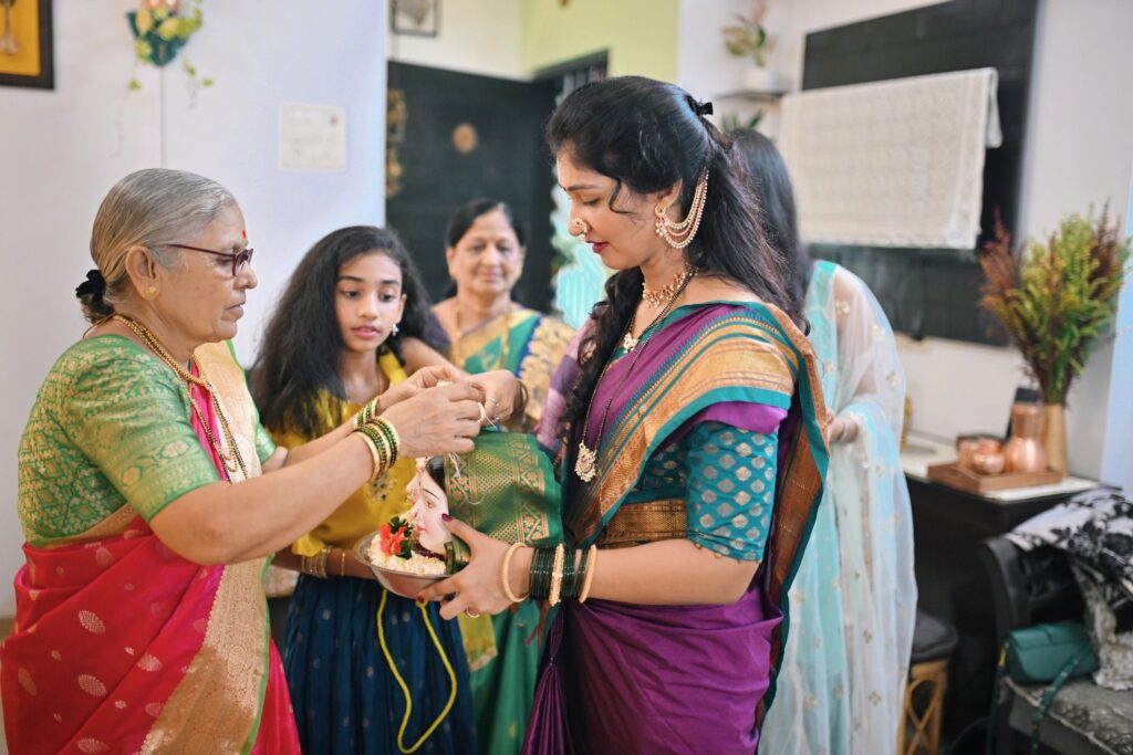 Indian family performing rituals while bringing the Gauri Idols inside home during Ganpati festival