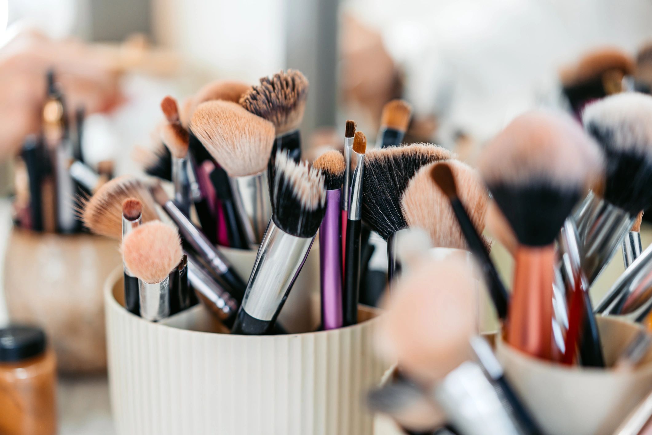 Makeup brushes and beauty products on a salon desk