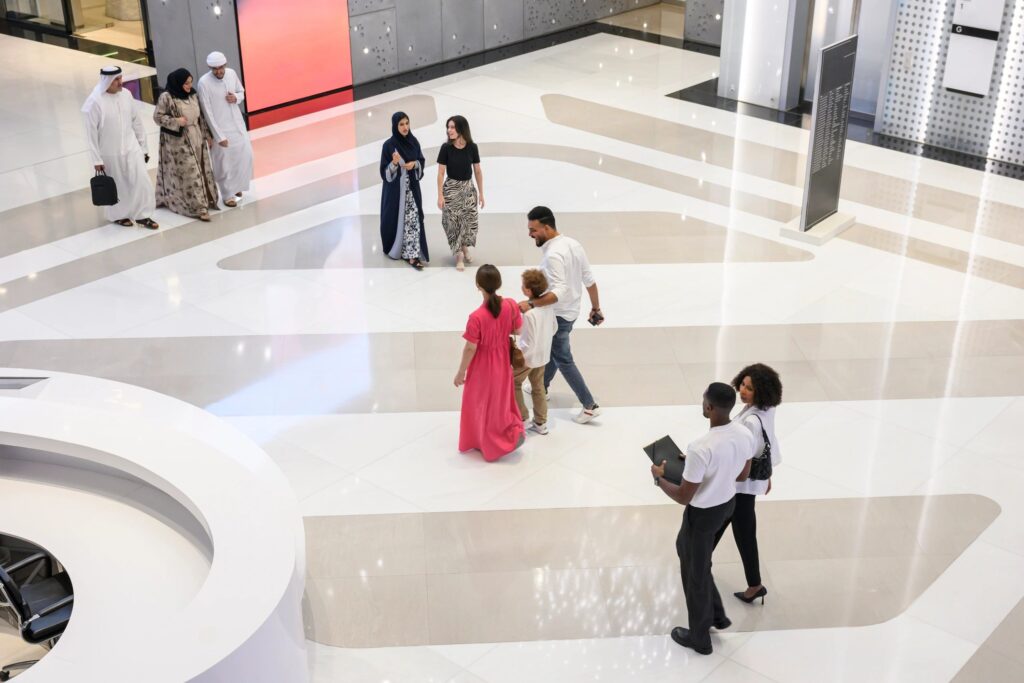 Diverse people walking in modern lobby of Dubai shopping mall