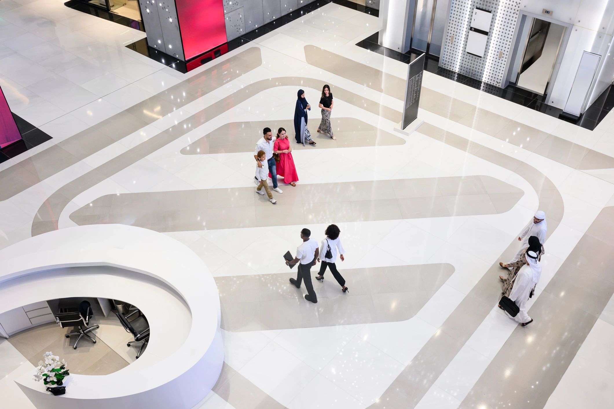 Shoppers walking through a bright mall interior
