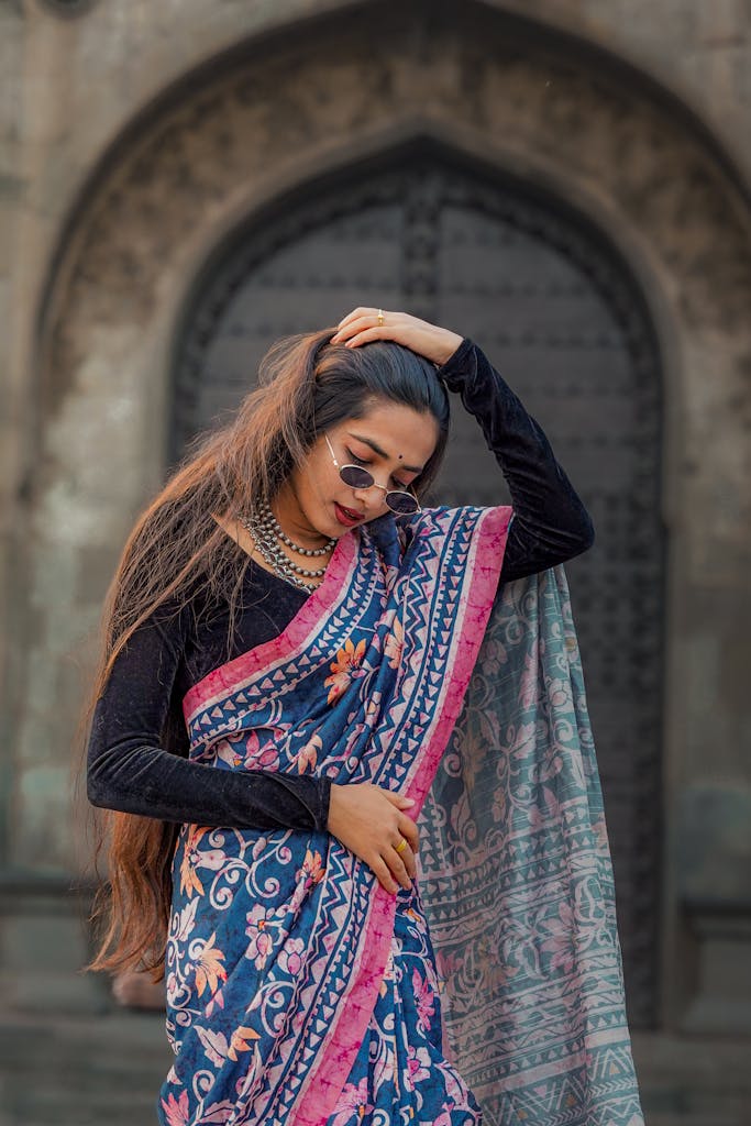 A fashionable Indian woman posing in a colorful saree outdoors, showcasing traditional style.